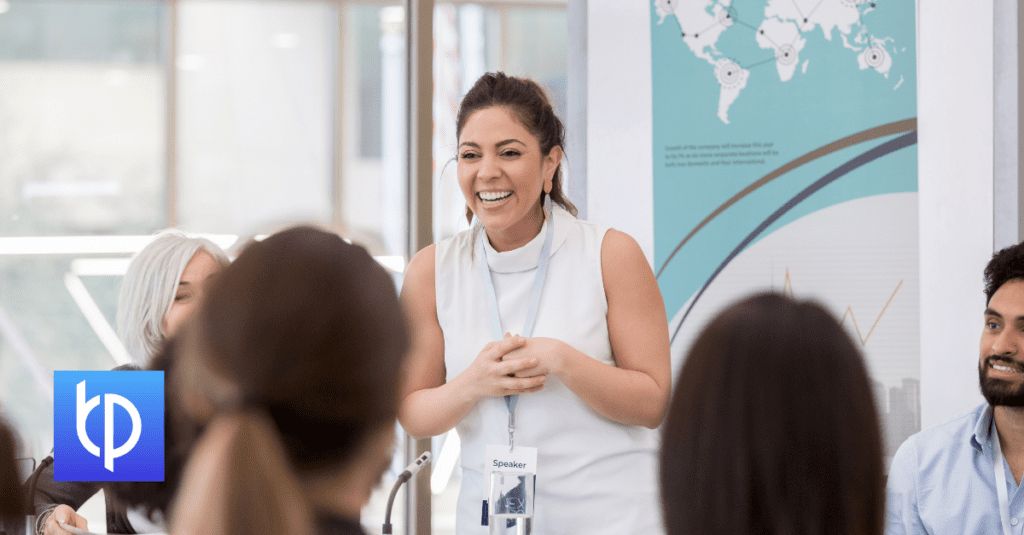 woman standing in a meeting smiling