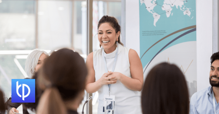 woman standing in a meeting smiling